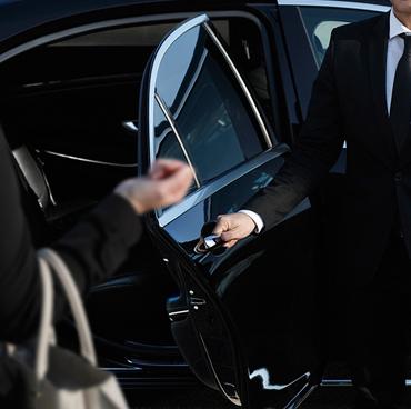 Chauffeur opening a car door for a traveller