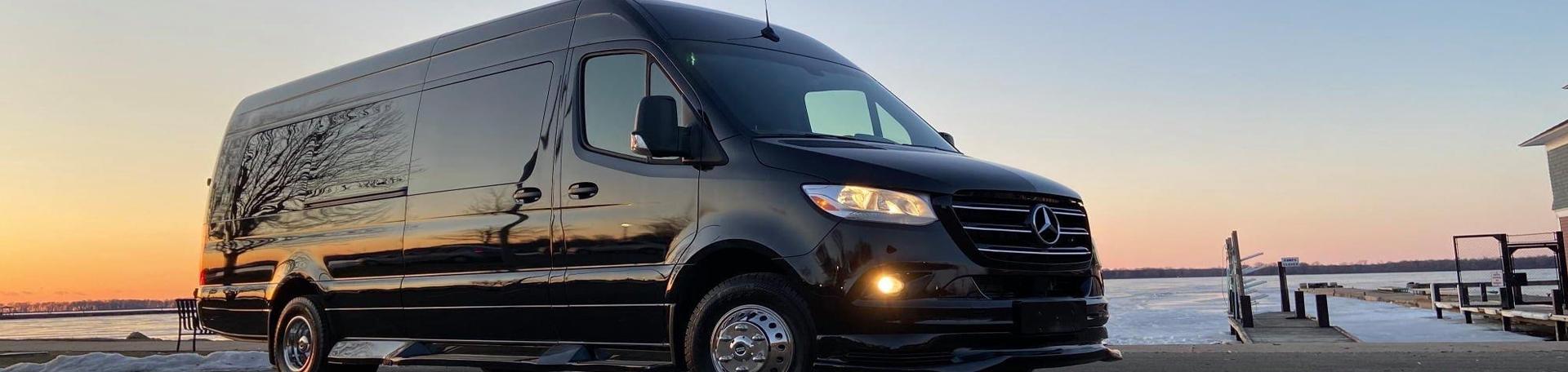 Black Mercedes Sprinter parked by the water at sunset
